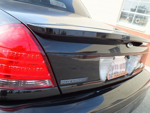 2003 Ford Crown Victoria - Detail of a black Crown Victoria rear quarter showing the Police Interceptor badge and tail light.