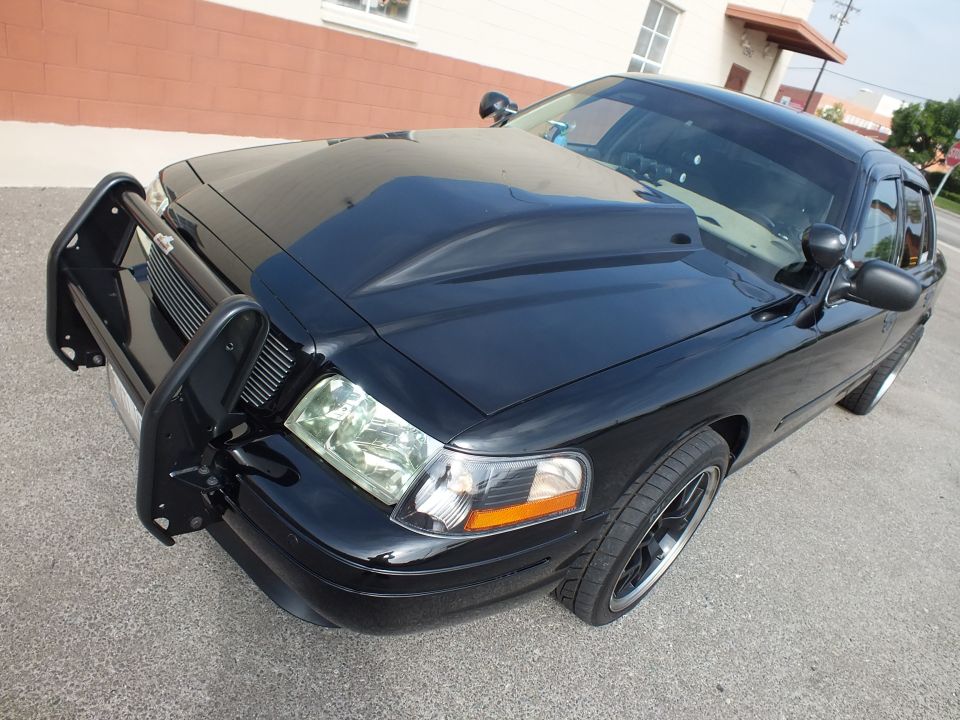 Black Ford Crown Victoria front with brush guard, hood, and aftermarket wheels
