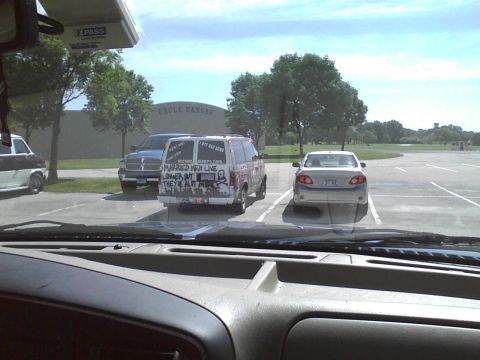 2003 Ford Crown Victoria - Van parked in a lot with various text and graphics on its rear doors.