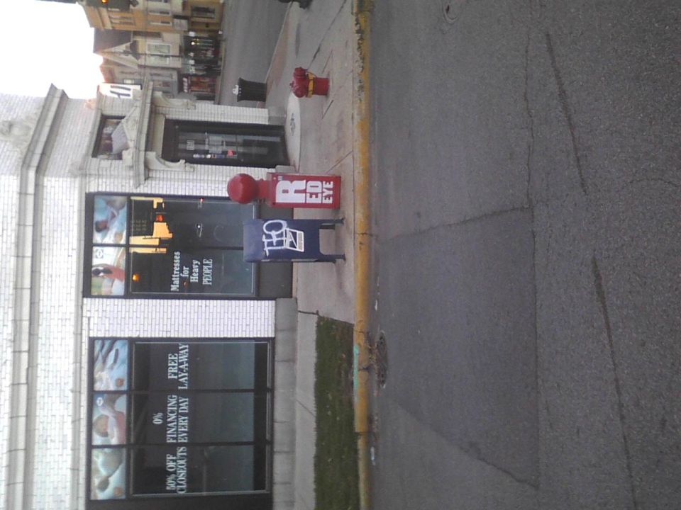 Street scene with red fire hydrant and newspaper boxes in front of a storefront