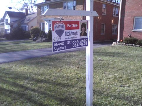 2003 Ford Crown Victoria - A real estate sign advertises a home for sale with agent contact details and a photo.
