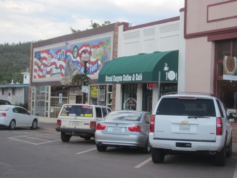 1991 Ford LTD Crown Victoria - A street scene shows several vehicles parked in front of businesses, including a white SUV and a silver sedan.