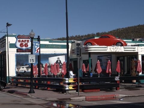 1991 Ford LTD Crown Victoria - A red coupe is displayed on the roof of a Route 66 cafe.