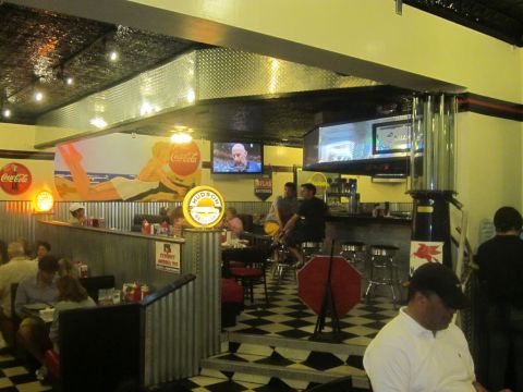 1991 Ford LTD Crown Victoria - Interior of a retro-themed diner with checkered floors and vintage decor.