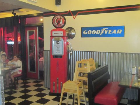 1991 Ford LTD Crown Victoria - A retro diner scene features a vintage gas pump and seating area with a prominent Goodyear sign on the wall.