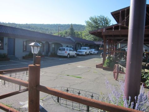 1991 Ford LTD Crown Victoria - A motel scene with three white vehicles parked in front of the rooms.