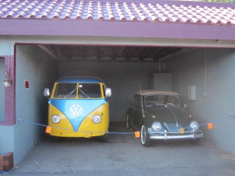 1991 Ford LTD Crown Victoria - Two classic Volkswagen vehicles, a Type 2 van and a Beetle convertible, are parked side-by-side in a garage.