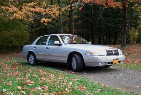 2008 Mercury Grand Marquis - A silver 2008 Mercury Grand Marquis sedan is seen from a three-quarter front view in an outdoor setting with fall colors.
