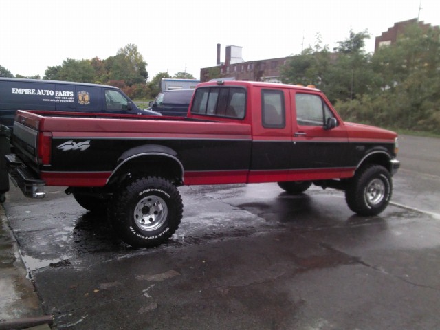 Red and black pickup truck with 4x4 decal on the side. It has BFGoodrich tires and aftermarket wheels