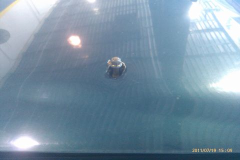 2000 Mercury Grand Marquis - Close-up of an antenna base on a car's hood, with reflections visible.