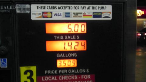 2000 Mercury Grand Marquis - A gas pump display shows transaction details, with a car visible in the background at night.