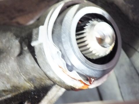 2003 Ford Crown Victoria - Splined yoke seated in a transmission output housing shows a worn seal and rust staining around the bore.