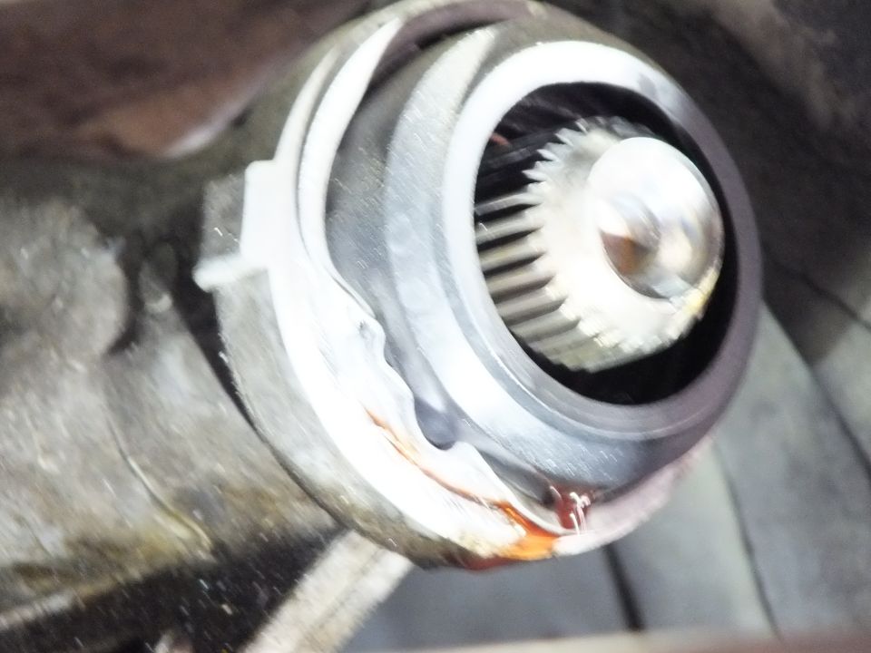 Close-up of splined driveshaft slip yoke and output shaft seal with surface rust on housing