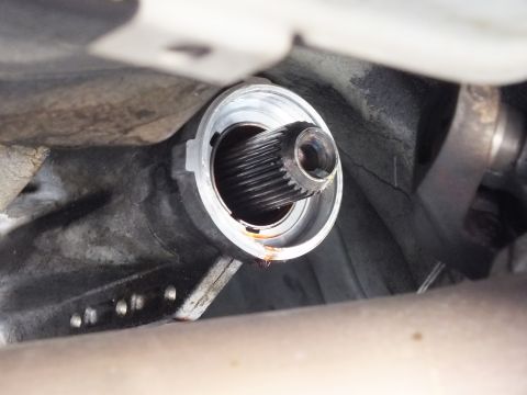2003 Ford Crown Victoria - Detail of a splined output shaft protruding from a transmission tailhousing bore, rust at the seal area.