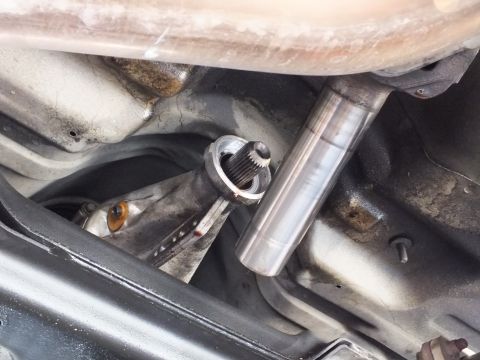2003 Ford Crown Victoria - splined yoke sits next to a polished driveshaft tube beneath the car, with exhaust and transmission nearby.