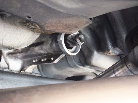 2003 Ford Crown Victoria - Splined output shaft tip extends from the transmission tailhousing in a tight underbody view; exhaust at right.