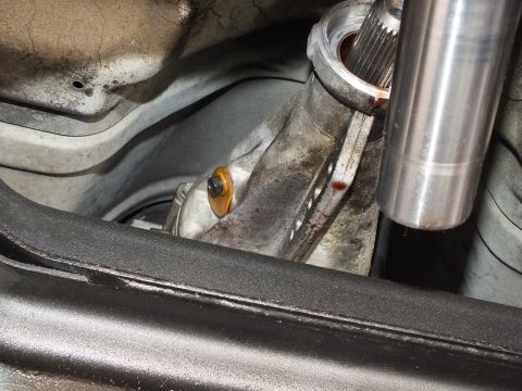 2003 Ford Crown Victoria - driveshaft tube and splined yoke rest above the transmission case in a close underbody view; rust on housing.