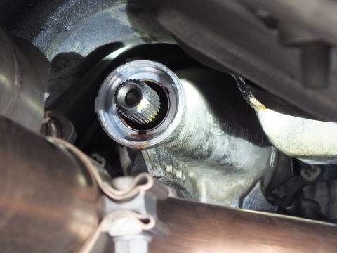 2003 Ford Crown Victoria - Splined slip yoke fits into the transmission output bore above crossing exhaust pipes in a tight underbody shot.
