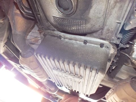 2003 Ford Crown Victoria - finned aftermarket-style transmission pan bolts to the case below the bellhousing; exhaust runs to the left.