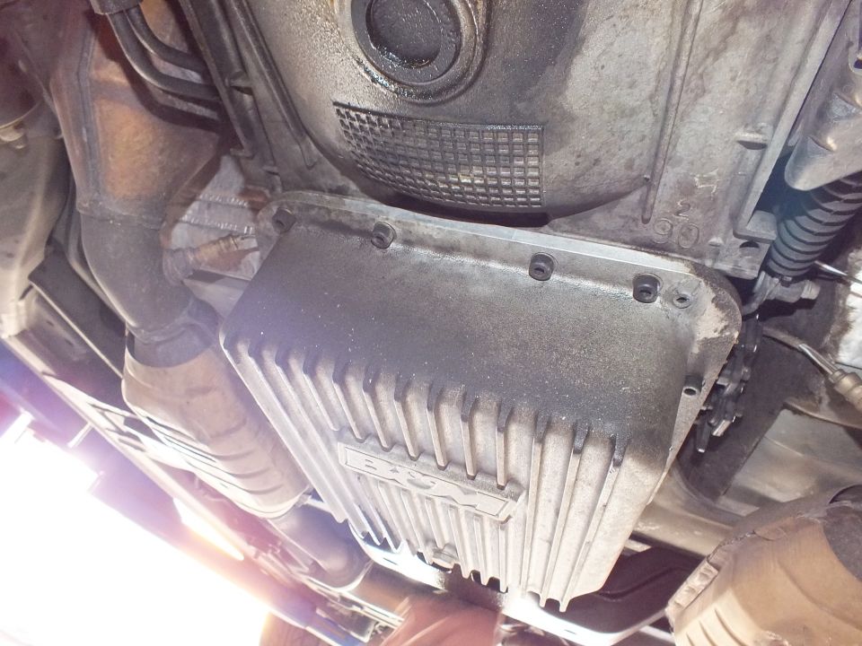 Finned automatic transmission pan under vehicle with bellhousing and exhaust visible