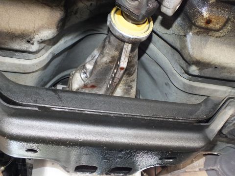 2003 Ford Crown Victoria - Driveshaft carrier bearing sits over a black crossmember and finned trans pan from below.