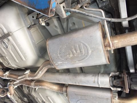 2003 Ford Crown Victoria - Factory muffler with embossed logo amid dual exhaust routing beneath the floorpan.