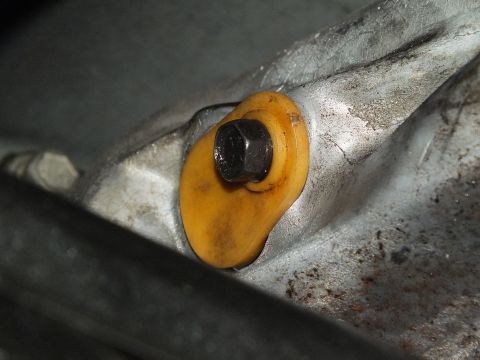 2003 Ford Crown Victoria - Bolt head seated in a yellow poly bushing mounted to a cast aluminum bracket.