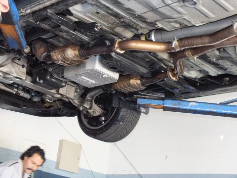 2003 Ford Crown Victoria - Underbody view of a lifted vehicle with transmission pan, exhaust and rear wheel visible.