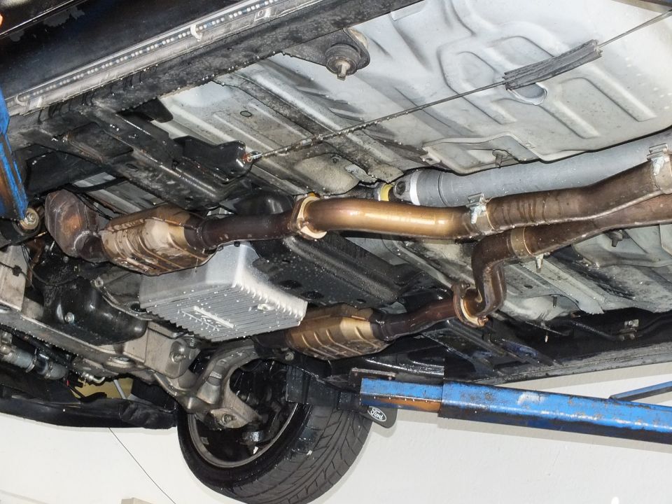 Undercarriage exhaust, catalytic converters and transmission pan of a vehicle on a blue lift arm