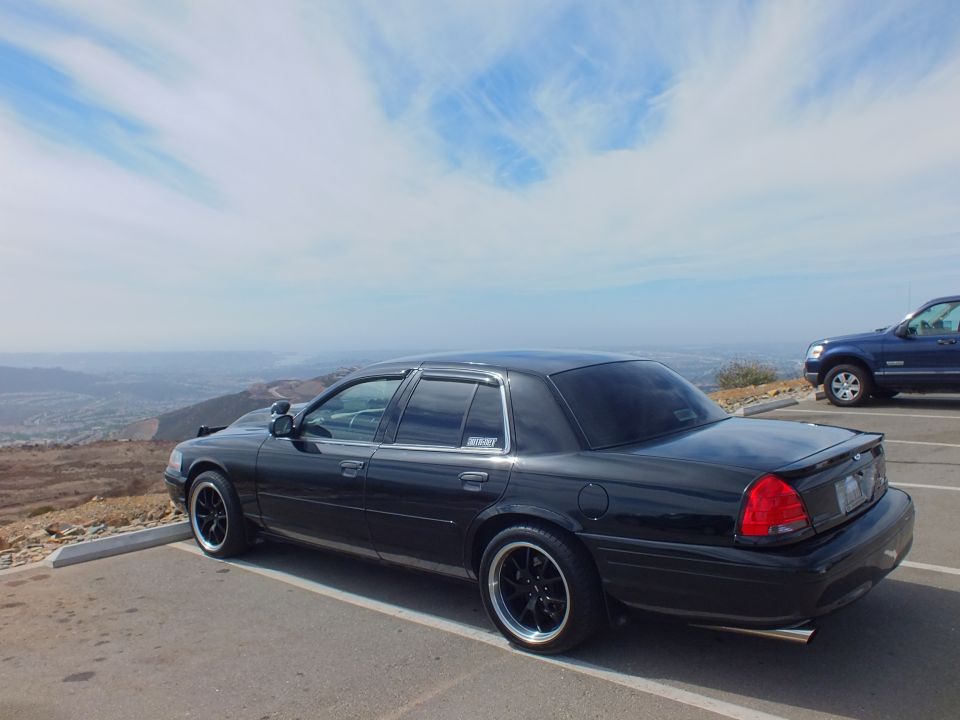 Black Crown Victoria rear quarter with tinted windows and black rims at hilltop lot