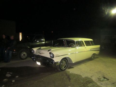 1991 Ford LTD Crown Victoria - A 1957 Chevrolet Nomad station wagon is parked next to a dark pickup truck.