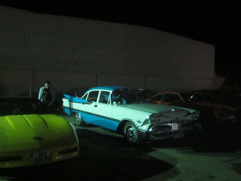 Two-tone blue and white sedan with fins, seen from a 3/4 front angle