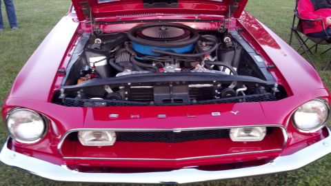 2007 Ford Mustang - A red Shelby Mustang is displayed with its hood open, revealing the engine and "SHELBY" lettering on the front grille.