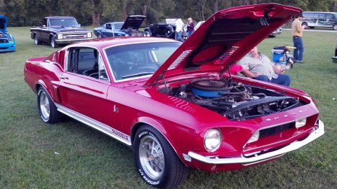2007 Ford Mustang - A classic red 1967 Shelby GT500 Mustang is displayed with its hood open at a car show.