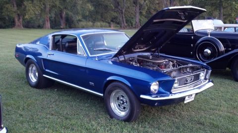 2007 Ford Mustang - A blue classic Ford Mustang fastback is displayed with its hood open, parked on grass next to another vintage vehicle.