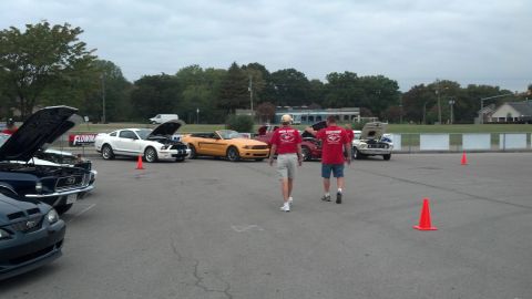 2007 Ford Mustang - Several Ford Mustangs are displayed with hoods open at an outdoor car show event.