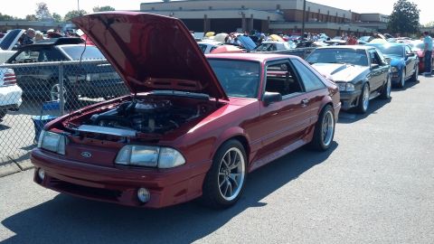 2007 Ford Mustang - A red 1990 Ford Mustang coupe is displayed with its hood open at a car show, alongside other vehicles.