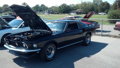 2007 Ford Mustang - A black 1969 Ford Mustang Mach 1 is displayed with its hood open at an outdoor car show.