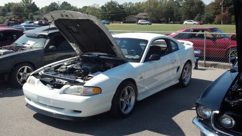 2007 Ford Mustang - A white 1994 Ford Mustang is displayed with its hood up at an outdoor car show.