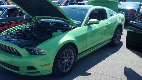 2007 Ford Mustang - A green 2010 Ford Mustang is displayed with its hood open at a car show.
