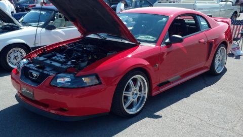 2007 Ford Mustang - A red Ford Mustang coupe is displayed with its hood open at a car show.