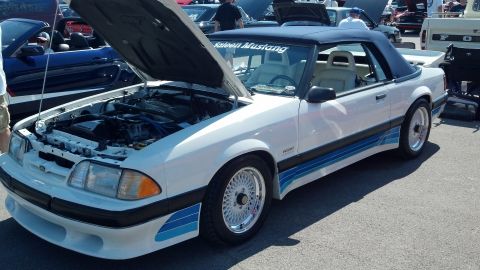 2007 Ford Mustang - White Saleen Mustang convertible with hood open, displaying its engine and side racing stripes. Another Mustang is visible in the backgroun…