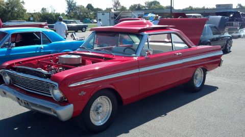 2007 Ford Mustang - A red 1963 Ford Falcon is displayed at a car show with its hood open.