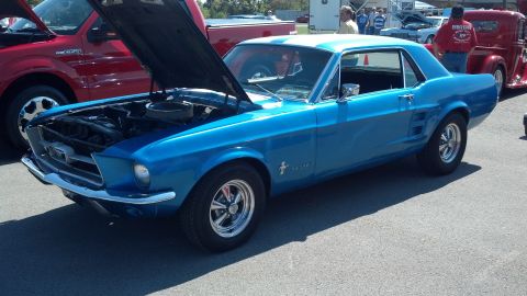2007 Ford Mustang - A bright blue 1967 Ford Mustang coupe is displayed with its hood open at a car show, alongside other vehicles.
