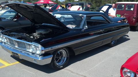 2007 Ford Mustang - A black 1964 Ford Galaxie 500 is displayed with its hood open at a car show.