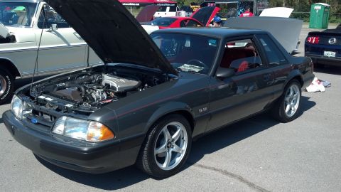 2007 Ford Mustang - Fox body Ford Mustang with its hood open at an outdoor car show.