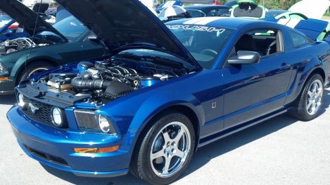2007 Ford Mustang - A blue 2007 Ford Mustang is displayed with its hood open, revealing the engine and a 'Roush' decal on the windshield.