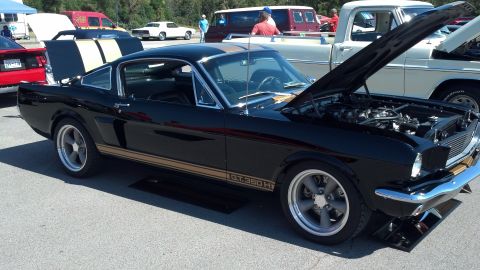 2007 Ford Mustang - A black 1966 Ford Mustang GT350H is displayed with its hood open at a car show.