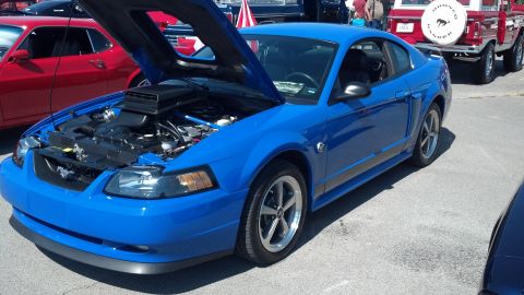 2007 Ford Mustang - A blue Ford Mustang is parked with its hood open, revealing the engine bay.