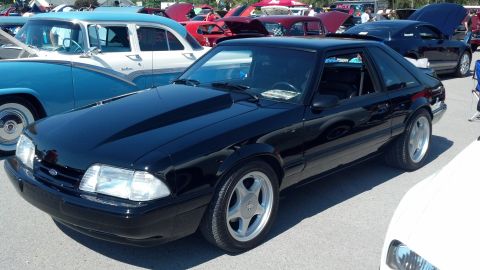 2007 Ford Mustang - A black Ford Mustang coupe, likely a 1993 model, is displayed at a car show with other vehicles present.